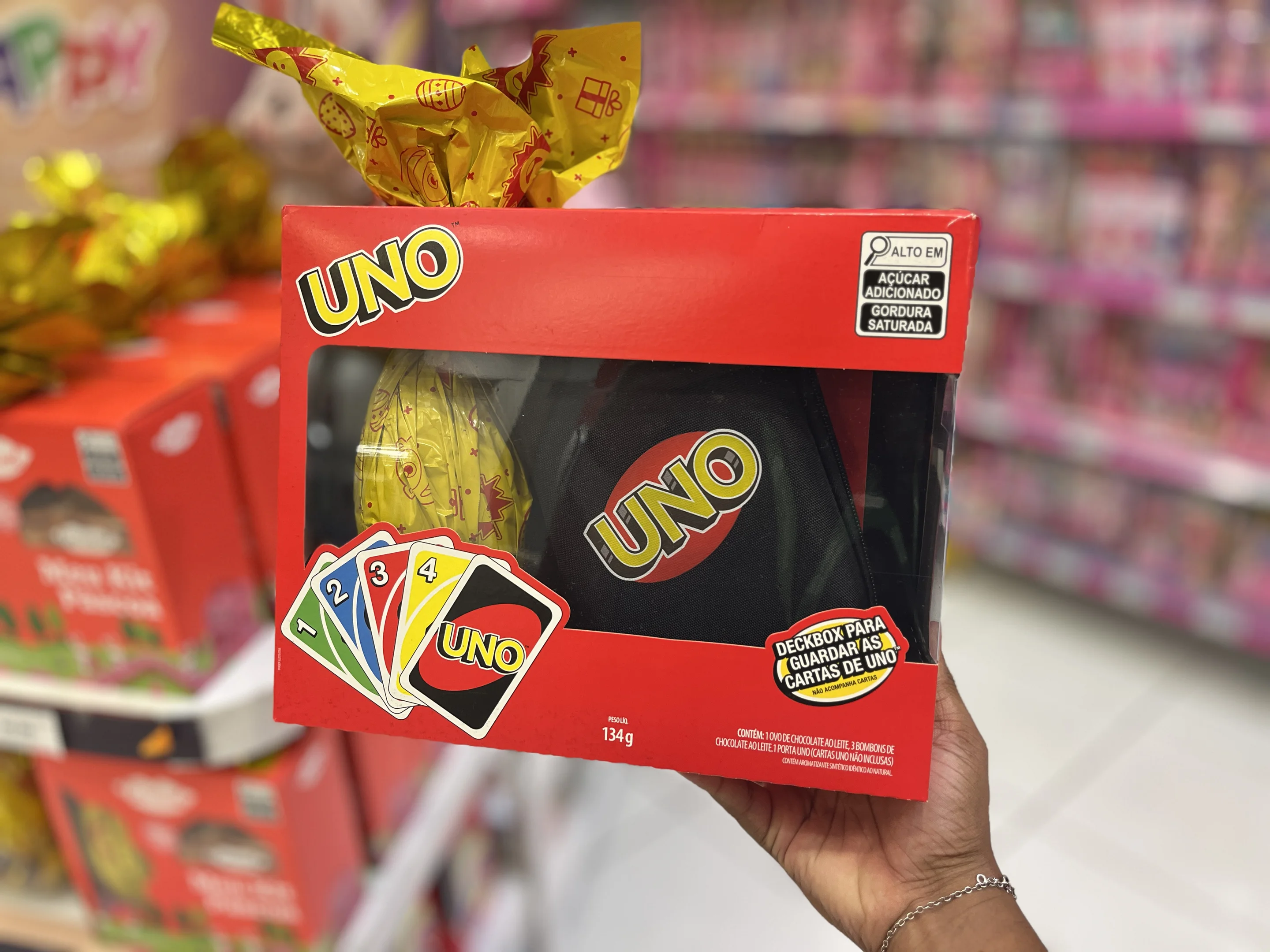 Mão masculina segurando ovo da páscoa temático do UNO, disponível na loja HiHappy.